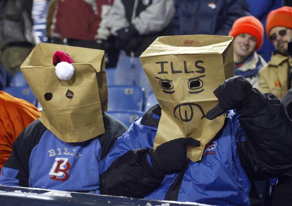 Buffalo Bills fans sit with paper bags over their heads at a game.  The Bills, despite their disappointing string of seasons, have many fans.