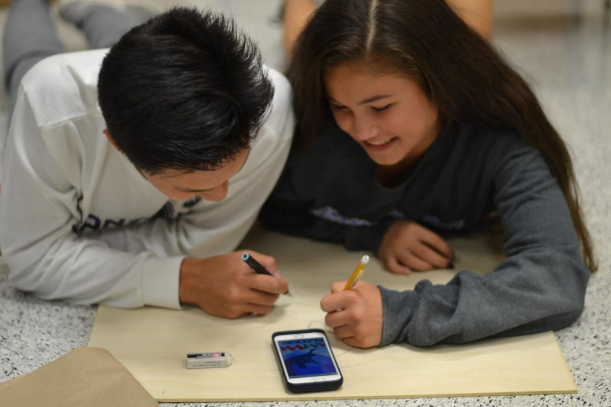Jia Yang Choo and Abby Asuncion work on a game for Fair at the Falls during PLC